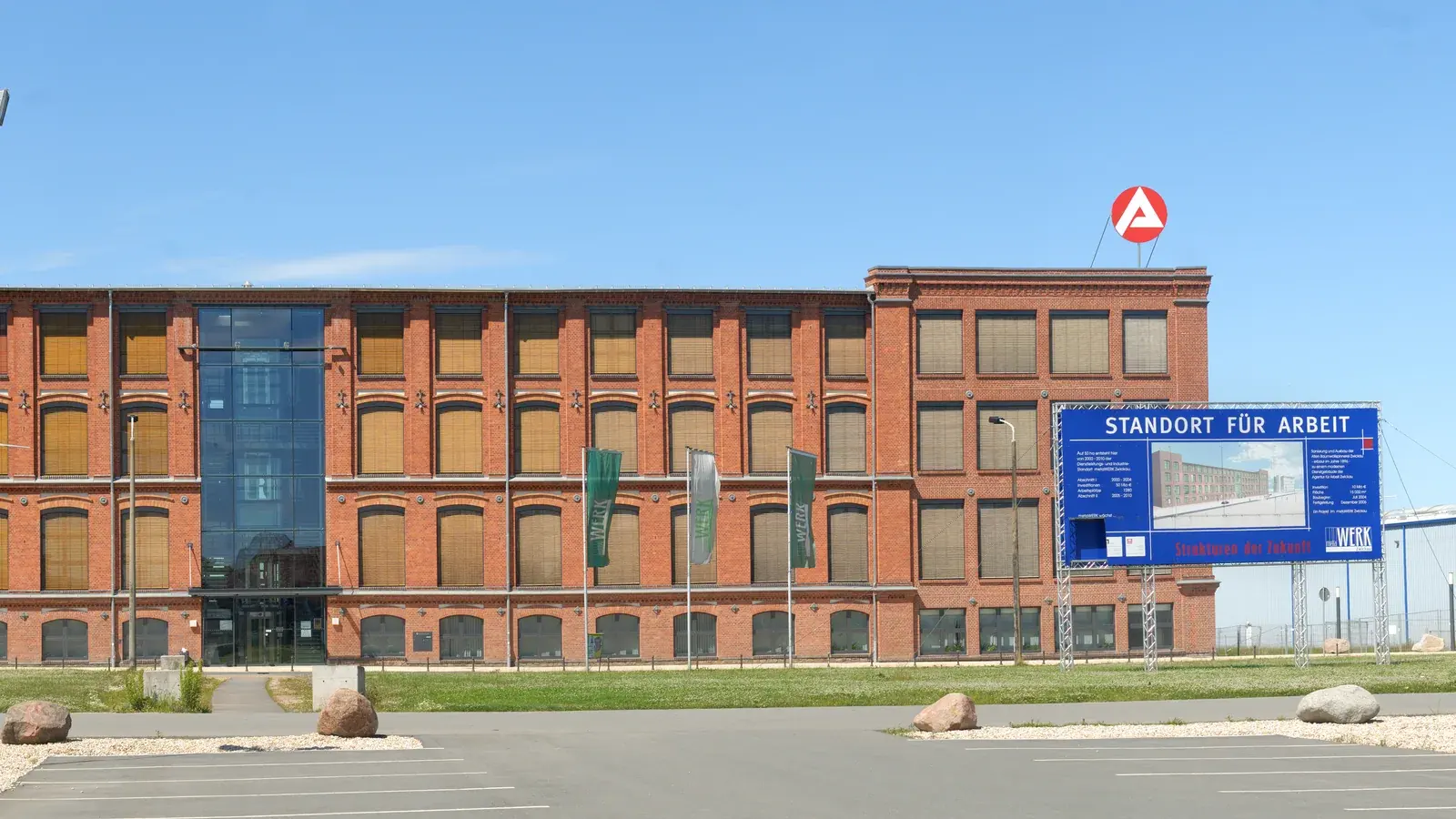 Breites Backsteingebäude in Zwickau mit BA-Zeichen und der Tafel Standort für Arbeit.