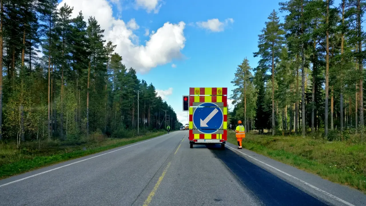 Mobile rote Baustellenampel neben einem Sicherungsfahrzeug auf einer Landstraße