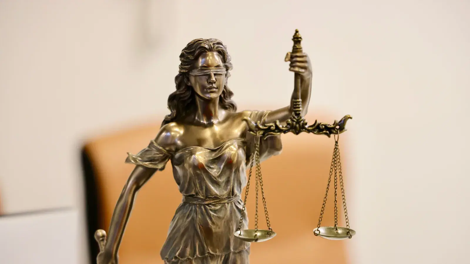 Nahaufnahme einer Justitia-Statue mit verbundenen Augen und einer Waage